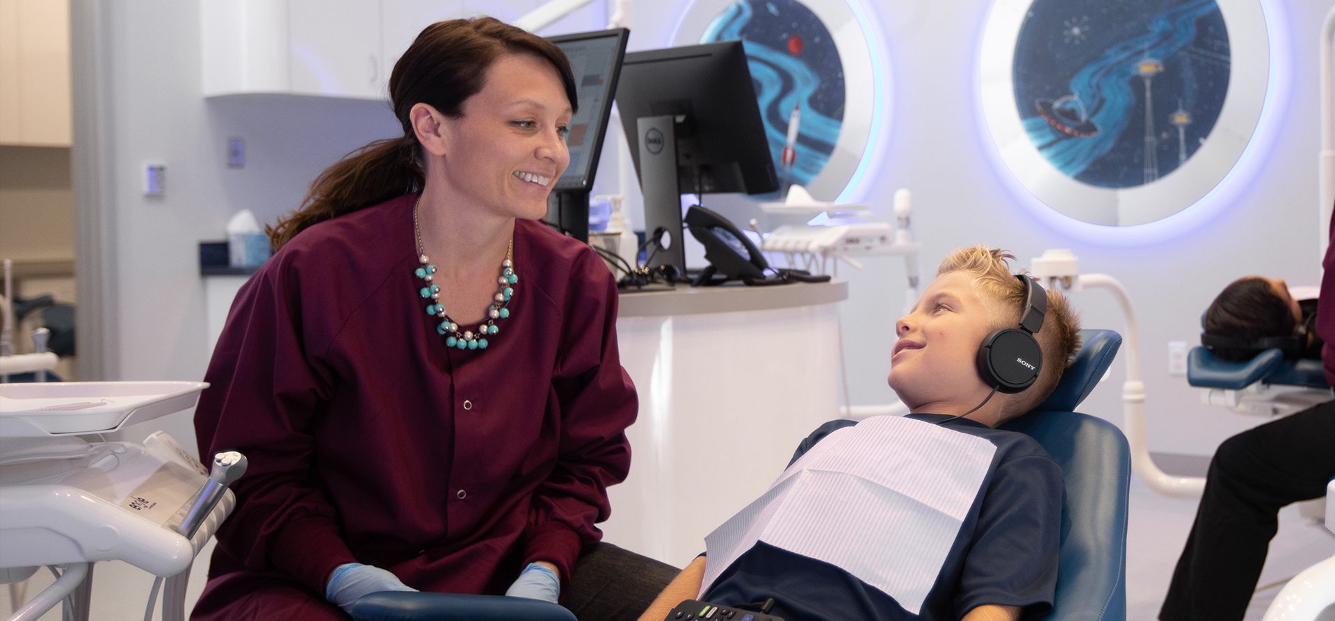 Dr. Julia (DMD) chats with a smiling child during an examination at Ventura Children's Dental